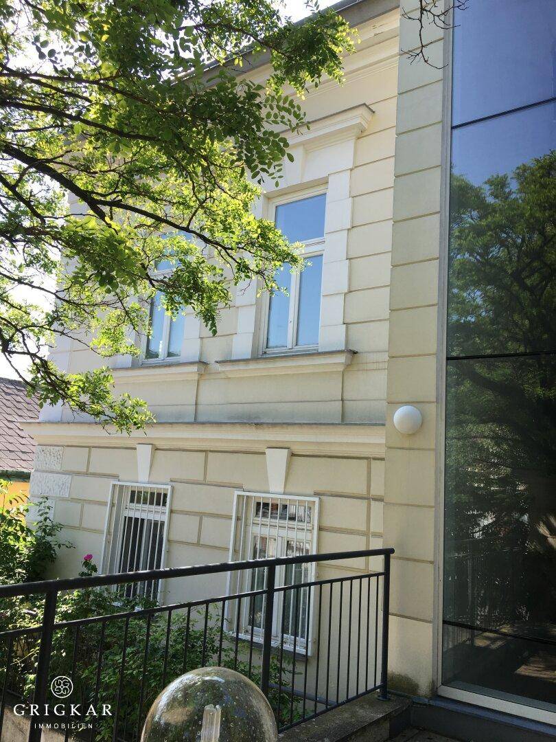 Historische Fassade eines Gebäudes mit klassischer Architektur und moderner Glasfront.