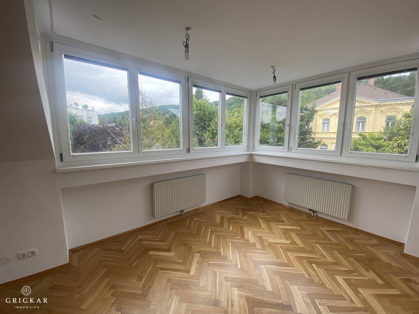 Lichtdurchfluteter Raum mit vielen Fenstern, die einen schönen Blick ins Grüne ermöglichen.