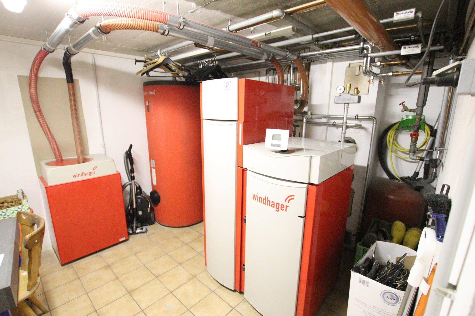 Heizraum im Keller mit modernen Windhager-Heizsystemen und Warmwasserspeichern.