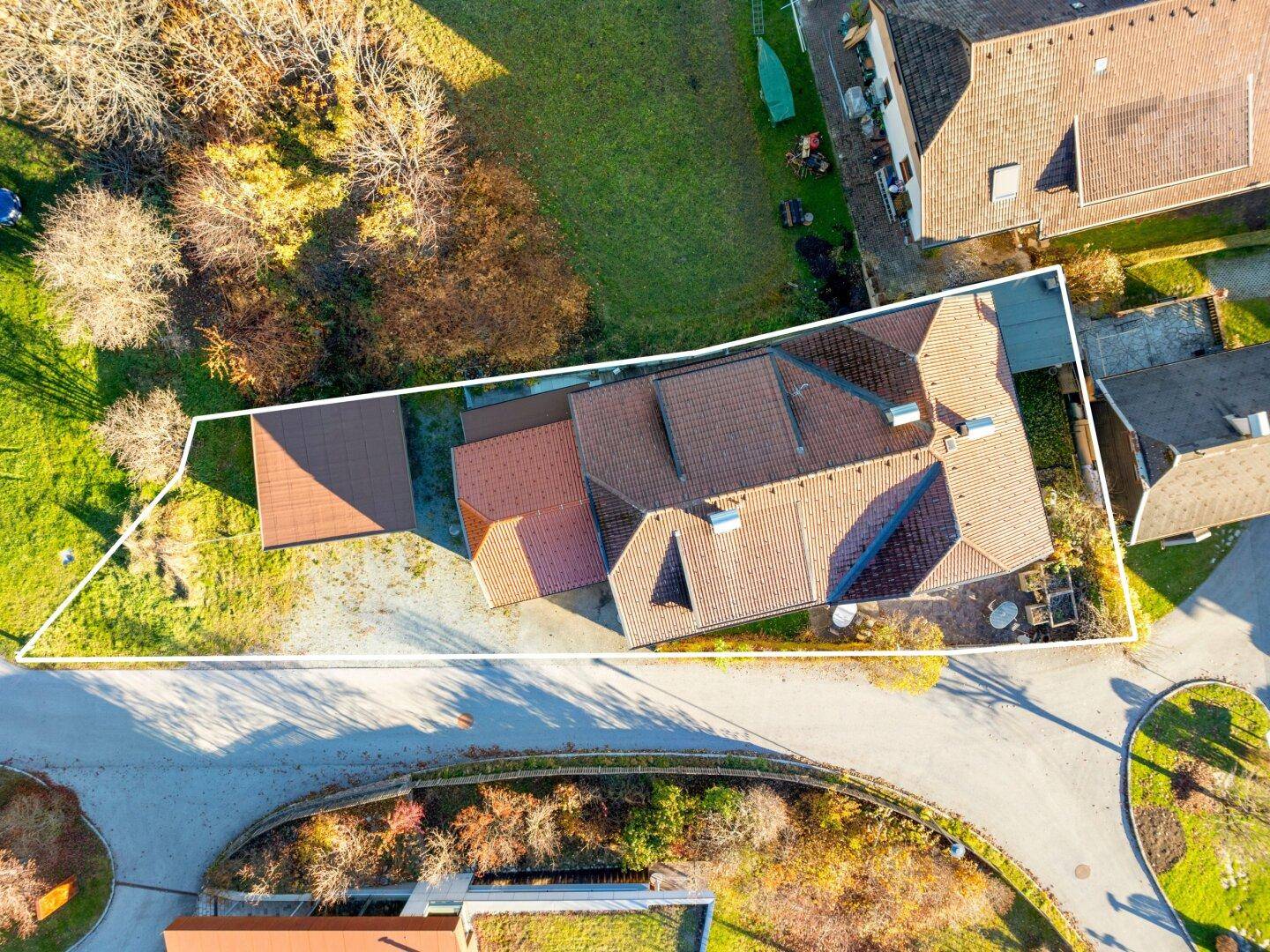Luftaufnahme des Grundstücks mit markierter Fläche und traditionellem Hausbau.