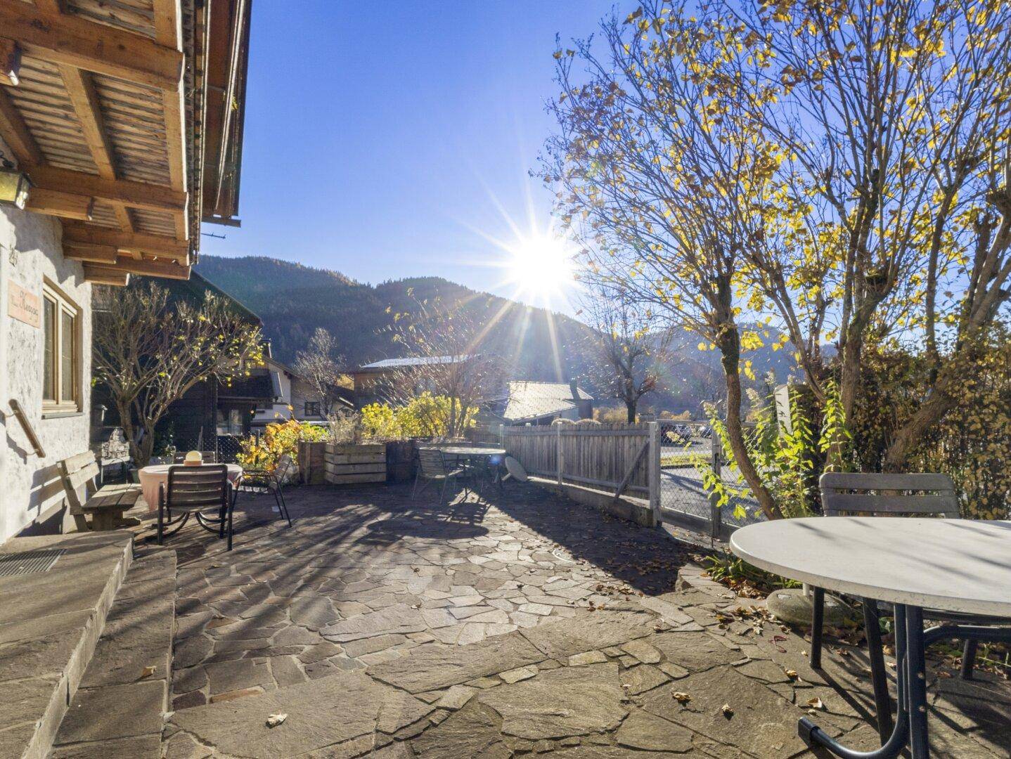 Großzügige Steinterrasse mit Blick auf die umliegende Natur und viel Sonnenschein.