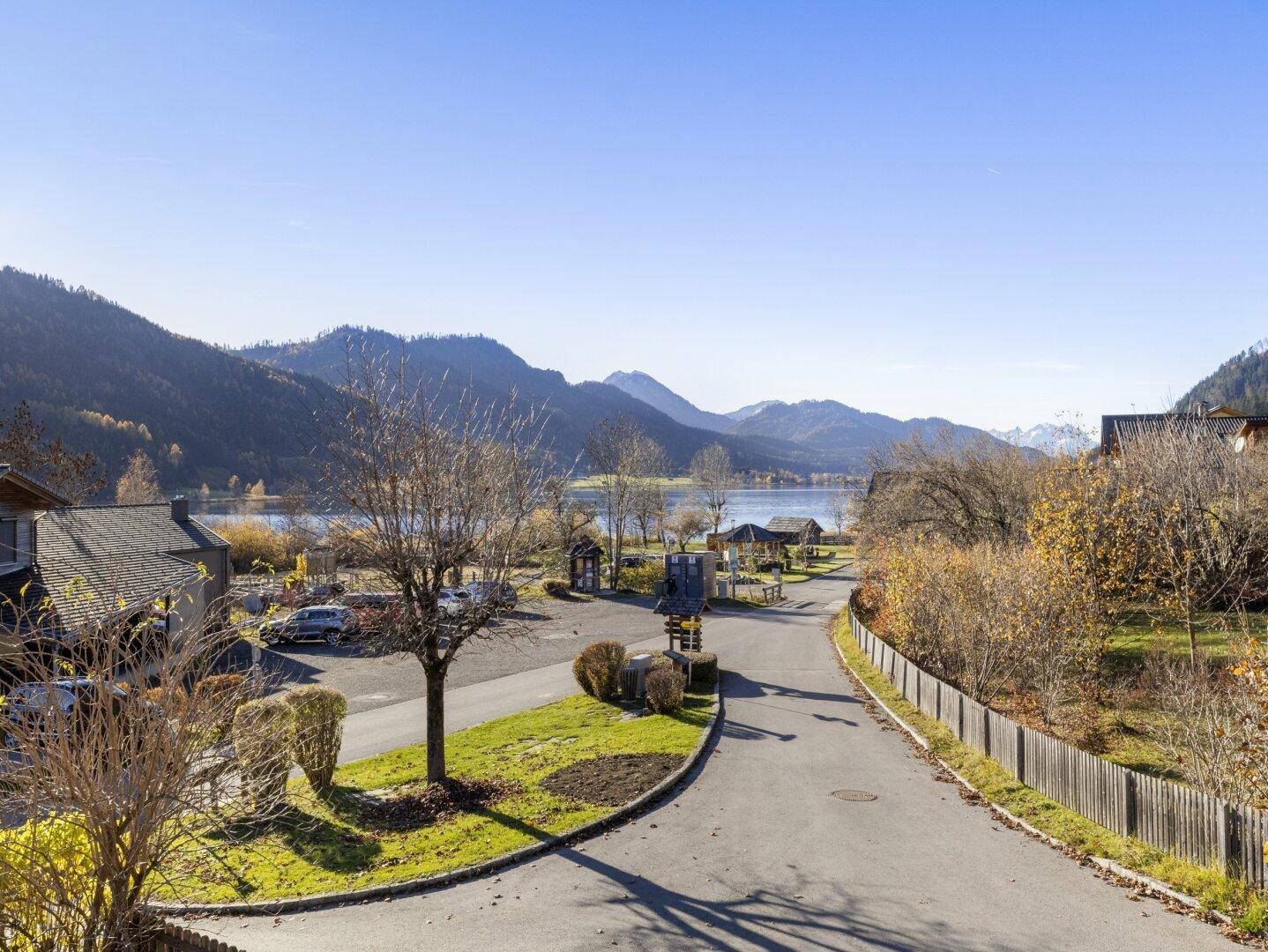 Weitblick von der Immobilie über die Straße zum See und die umliegende Berglandschaft.
