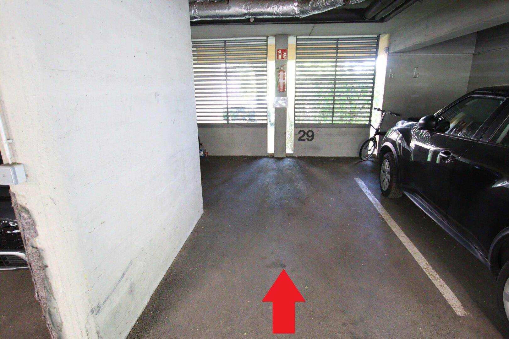 Einzelner Parkplatz in der Tiefgarage mit Nummerierung und Fenster zur Belüftung.