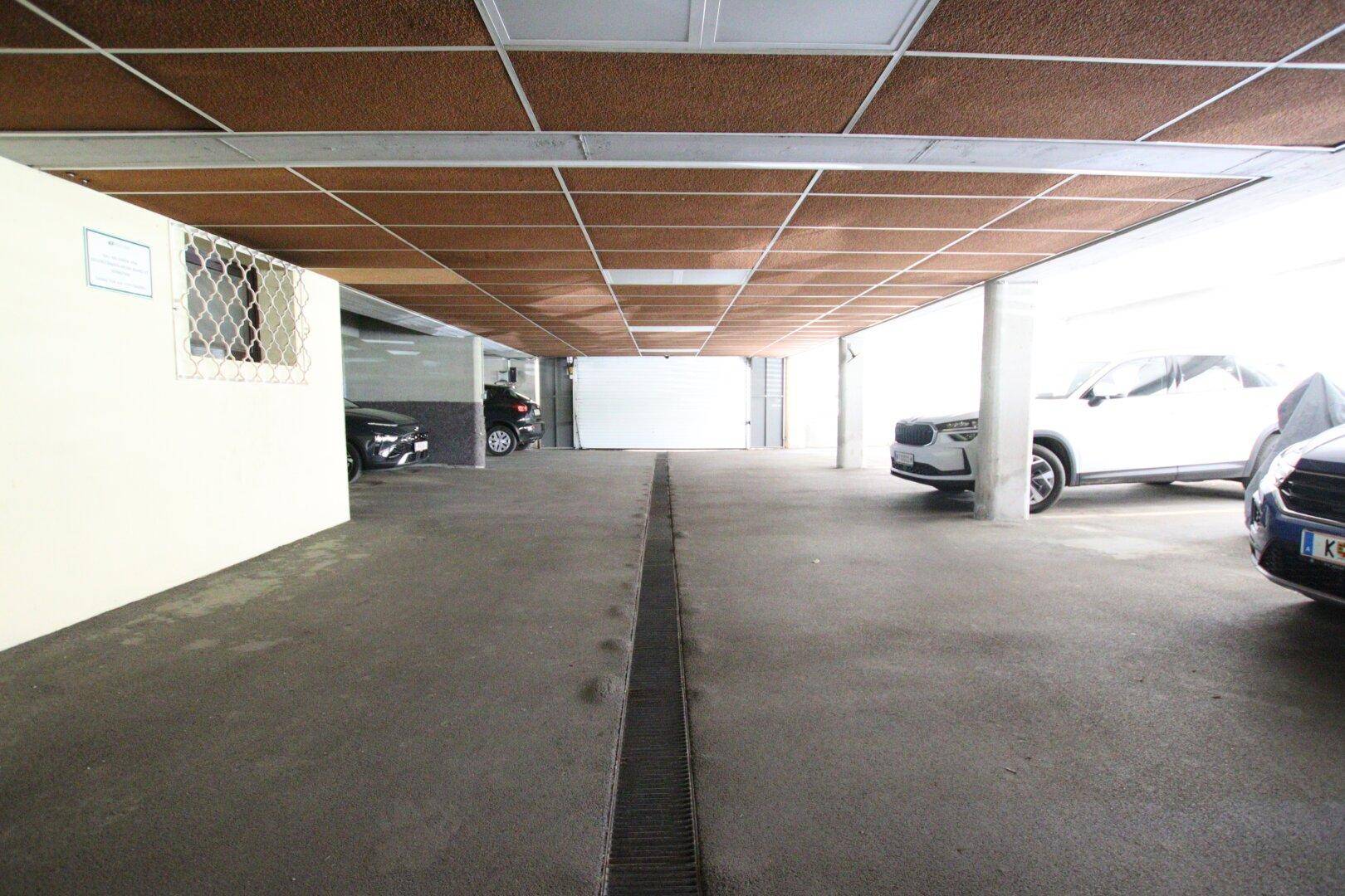 Geräumige Tiefgarage mit mehreren Stellplätzen und Betonboden.