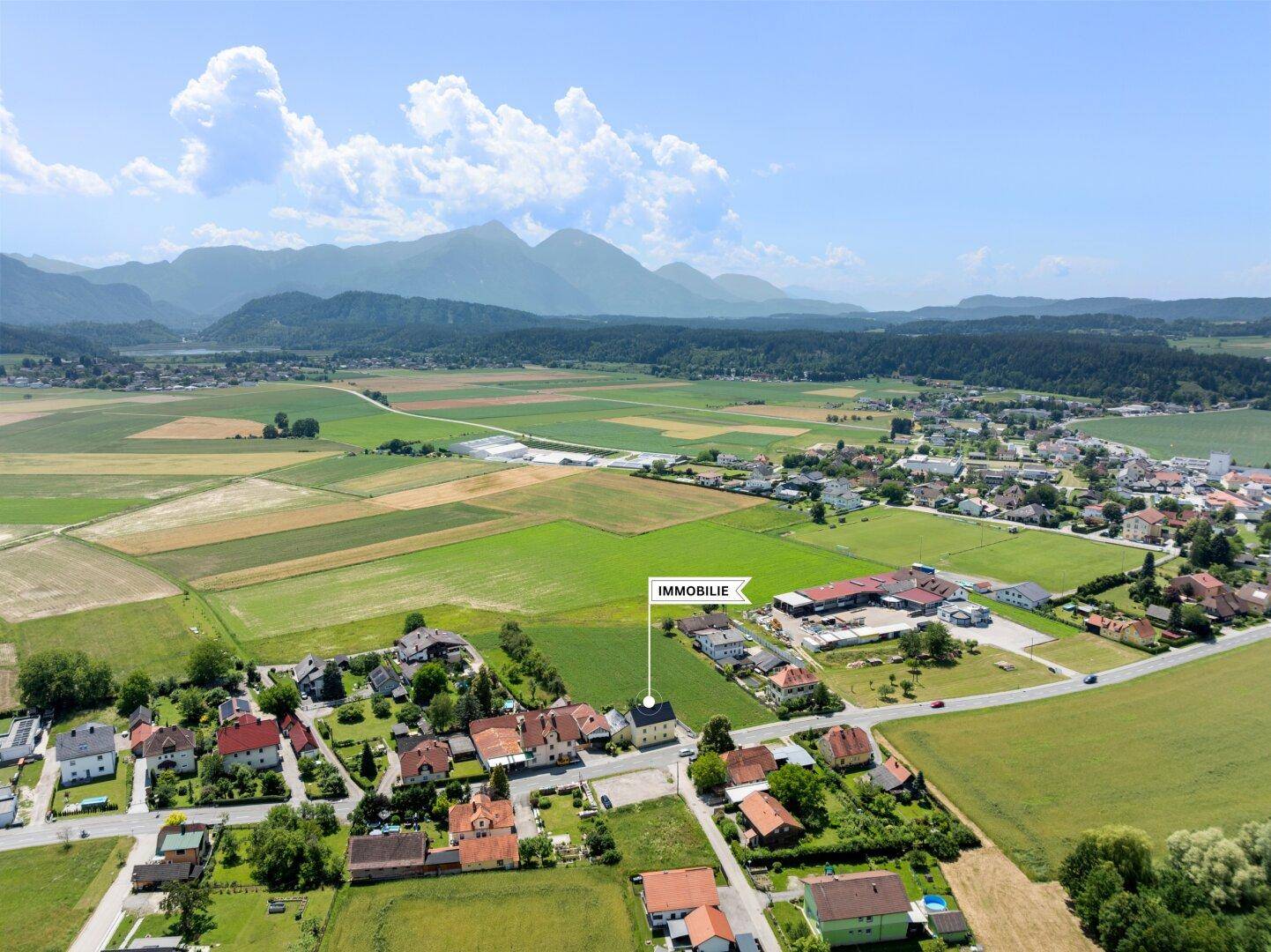 Übersichtliche Luftaufnahme der Immobilie in einer ländlichen Gegend mit Bergpanorama.