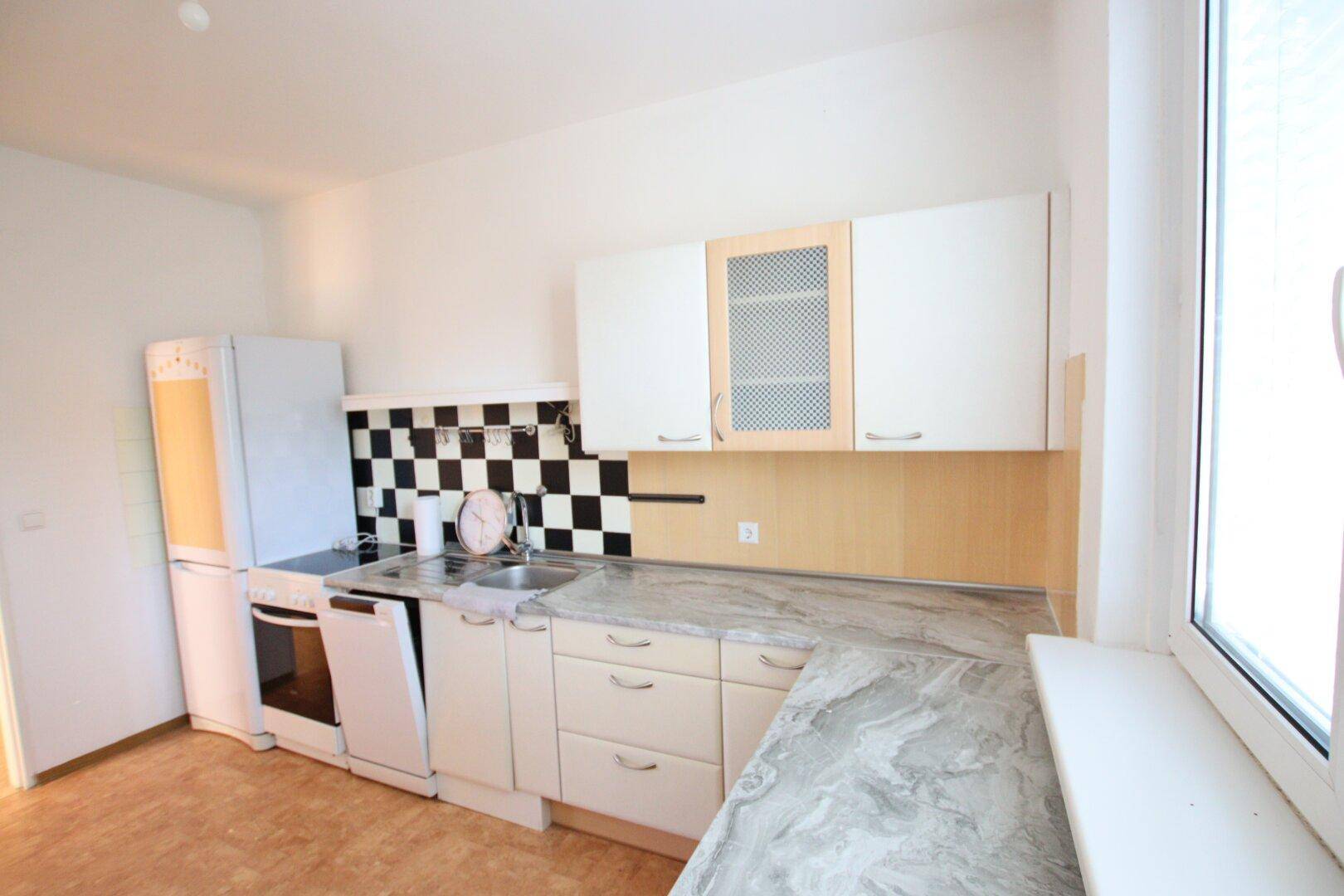 Küche mit hellen Schränken und marmorierter Arbeitsplatte, bietet ausreichend Platz zum Kochen.