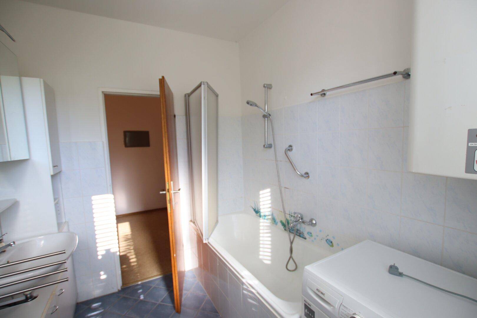 Badezimmer mit Badewanne und Duschvorrichtung, bietet eine praktische Lösung für die Körperpflege.