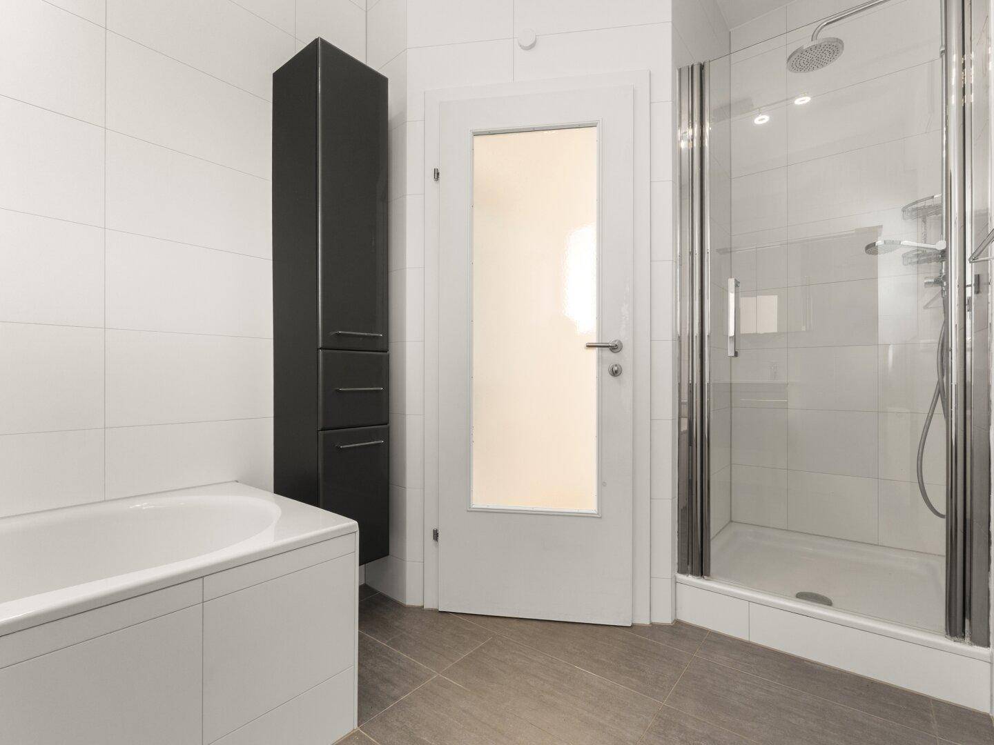Badezimmer mit Badewanne, separater Dusche und modernem, funktionalem Design.