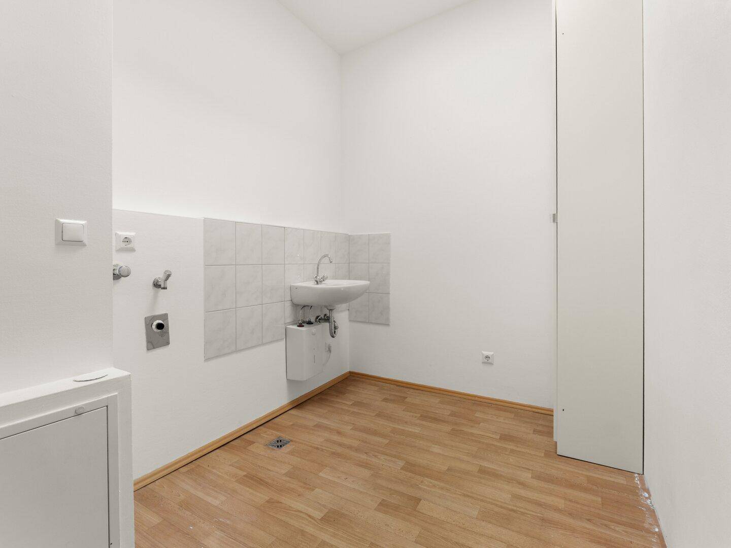 Praktischer Hauswirtschaftsraum mit Waschbecken und allen notwendigen Anschlüssen.