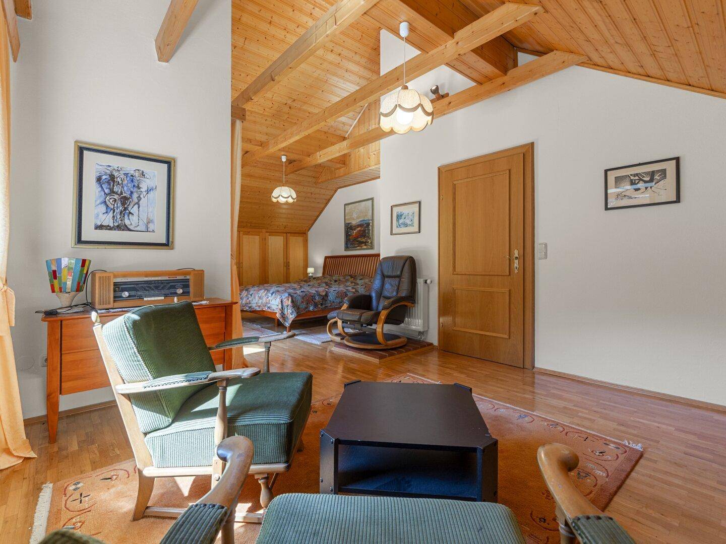 Gemütliches Schlafzimmer mit Holzbalkendecke, traditionellen Möbeln und viel Holz.