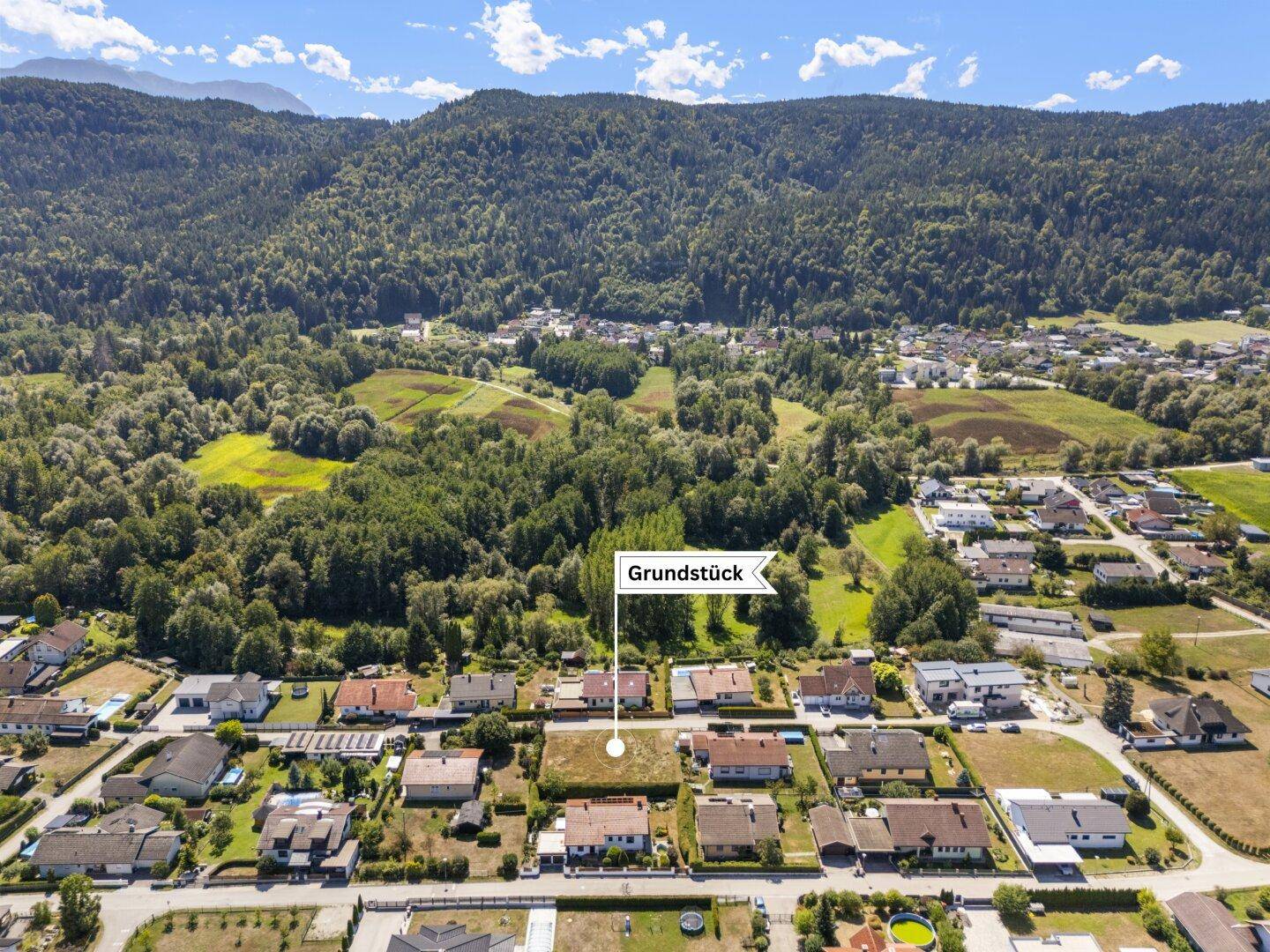 Übersichtliche Luftaufnahme des Grundstücks, eingebettet in die ländliche Umgebung mit Bergen und Wäldern.