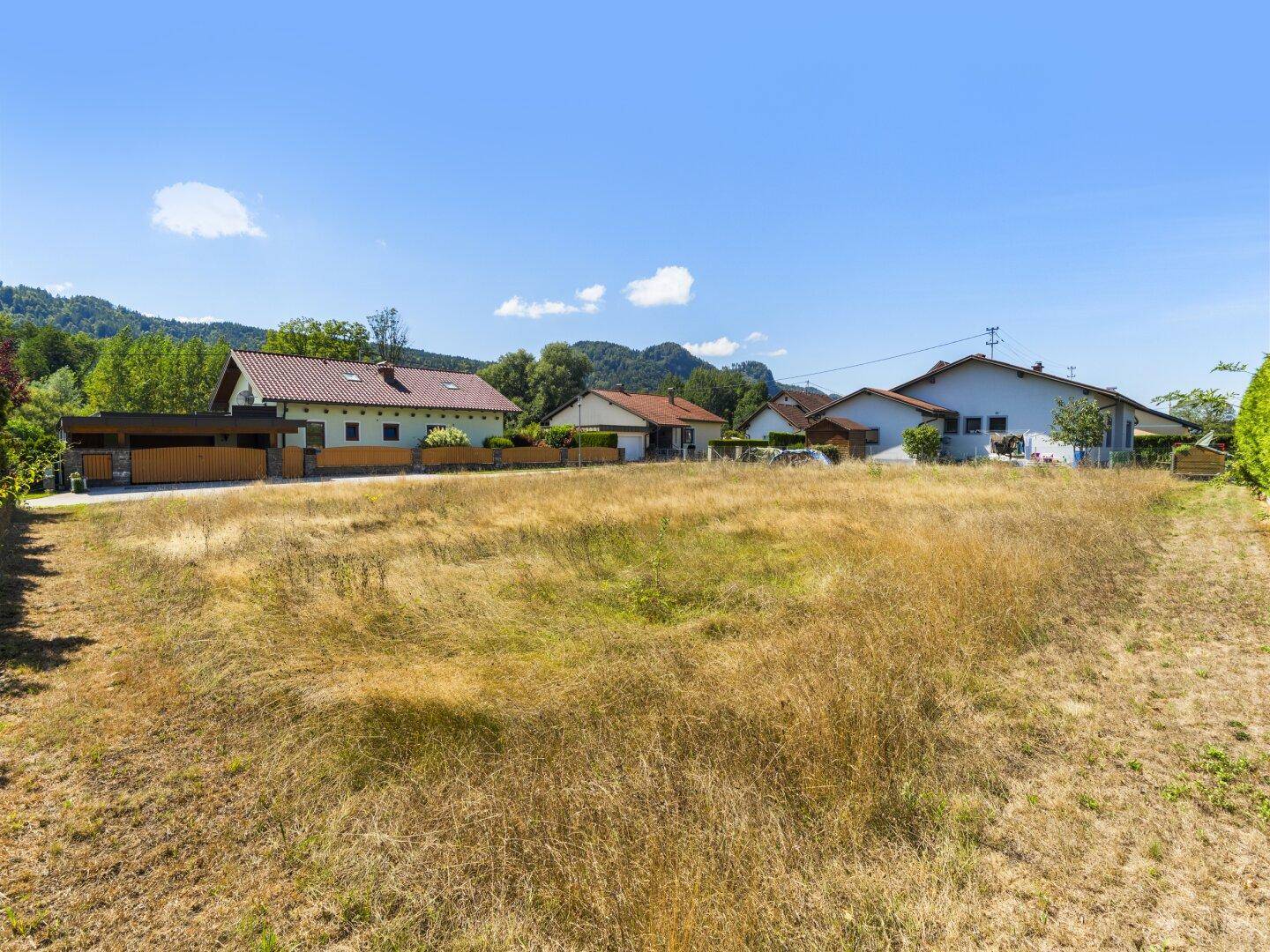 Unbebautes Grundstück mit weitem Blick auf die Nachbarschaft und die malerische Bergkulisse.