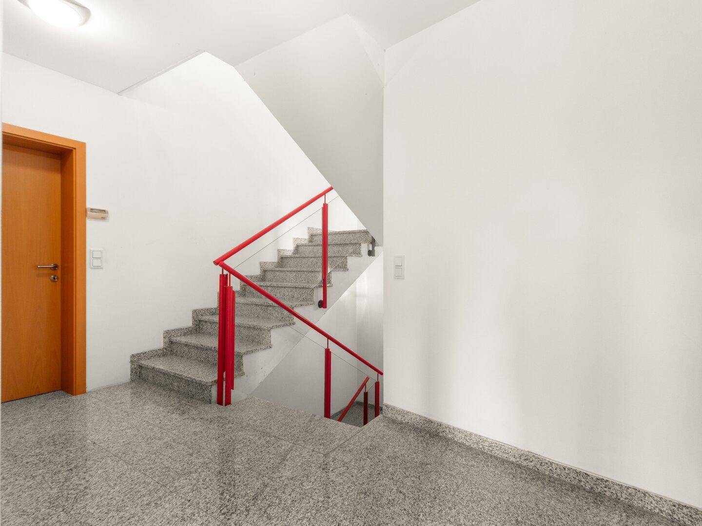 Geräumiger Eingangsbereich mit Granitboden und Treppe, die in die oberen Stockwerke führt.
