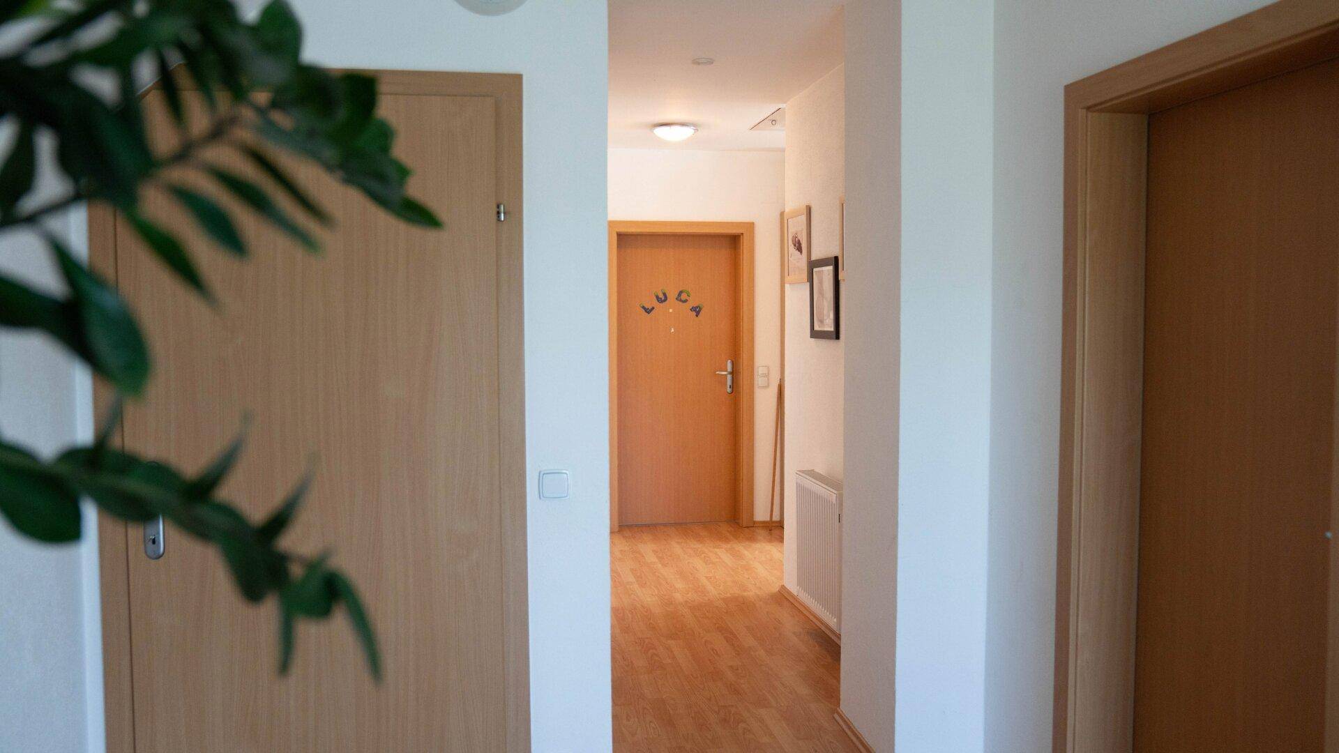 Heller Flur mit Holztüren und Parkettboden, der zu weiteren Räumen führt.