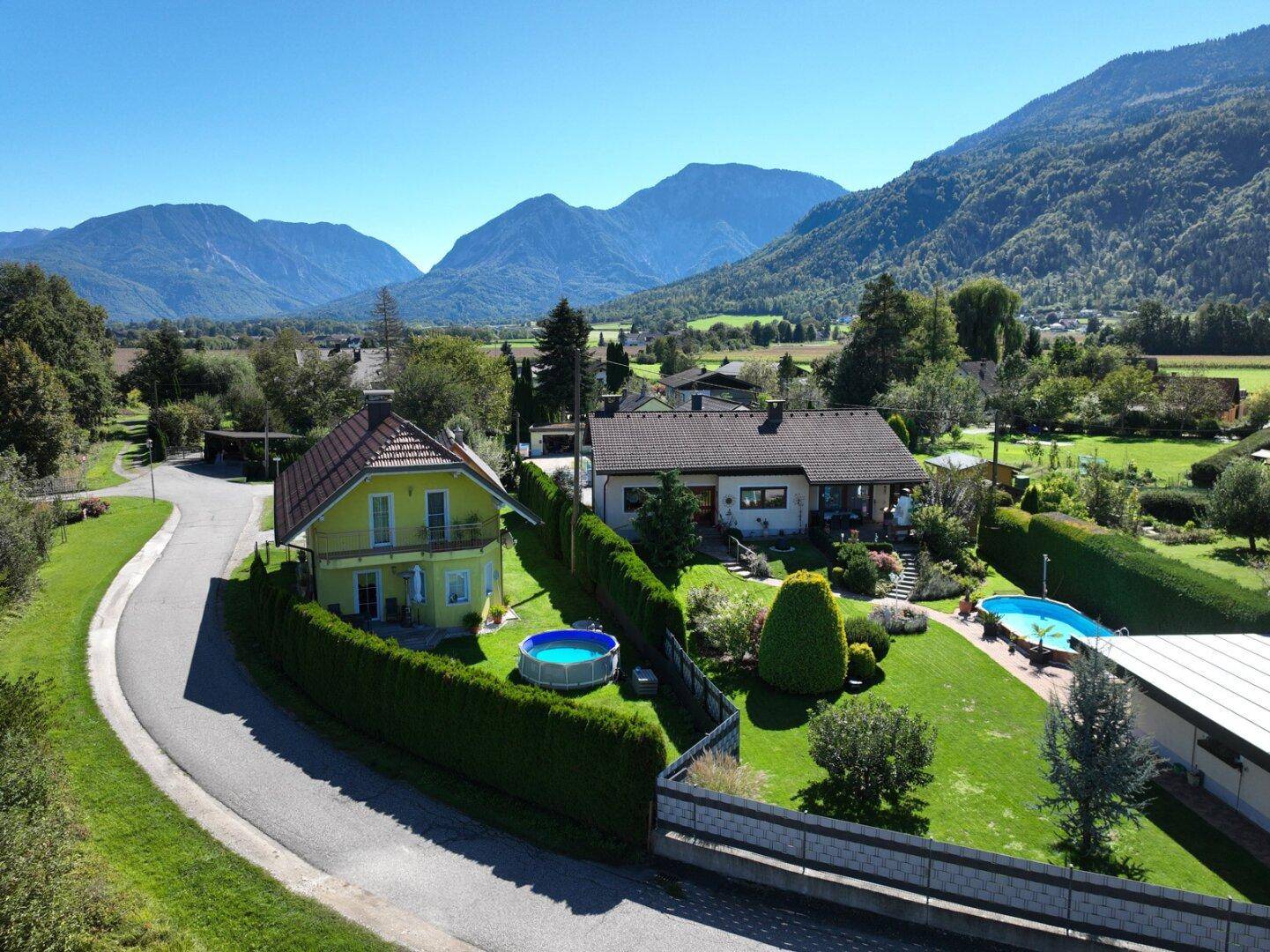 Gepflegter Gartenbereich mit Aufstellpool und Blick auf die umliegende Berglandschaft.