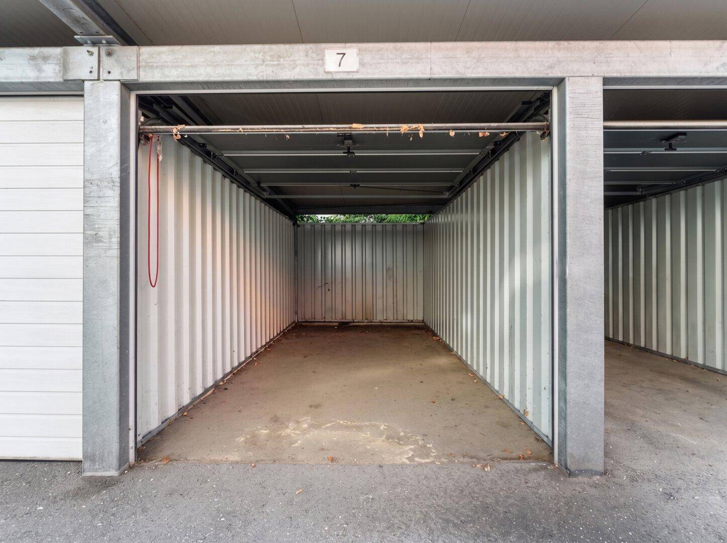 Leere Einzelgarage mit Betonboden und Metallwänden.