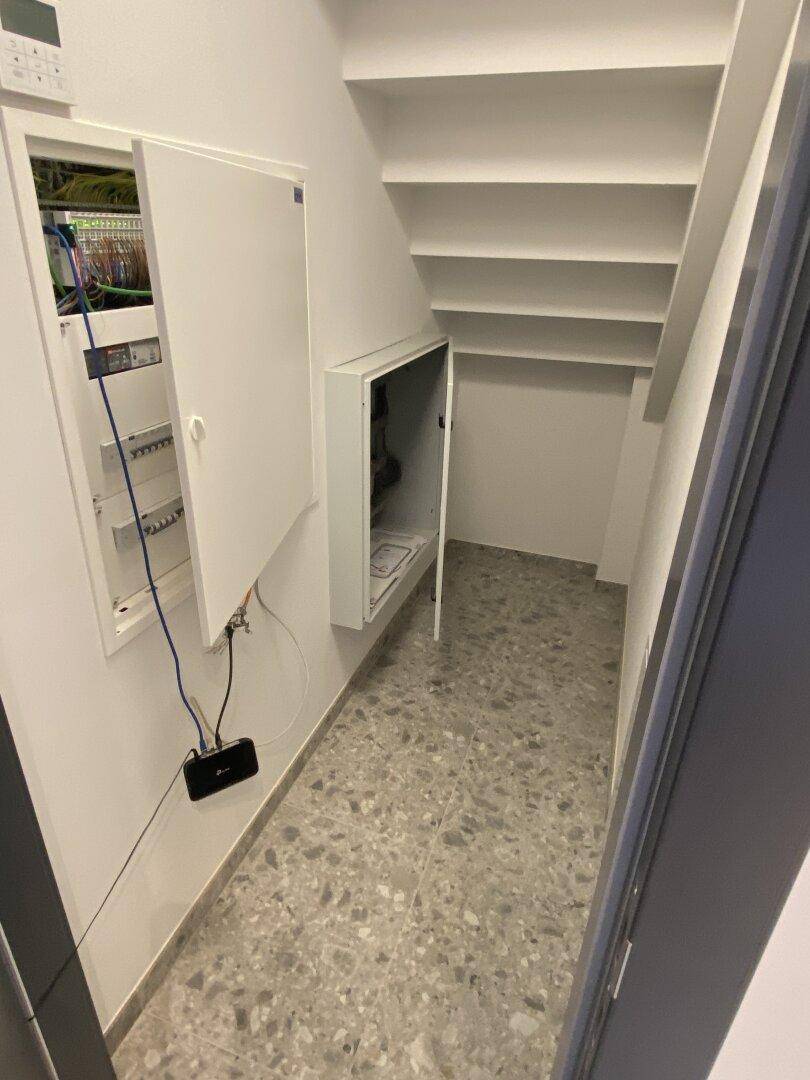 Praktischer Stauraum unter der Treppe mit Zugang zu den Elektroinstallationen und Sicherungskästen.