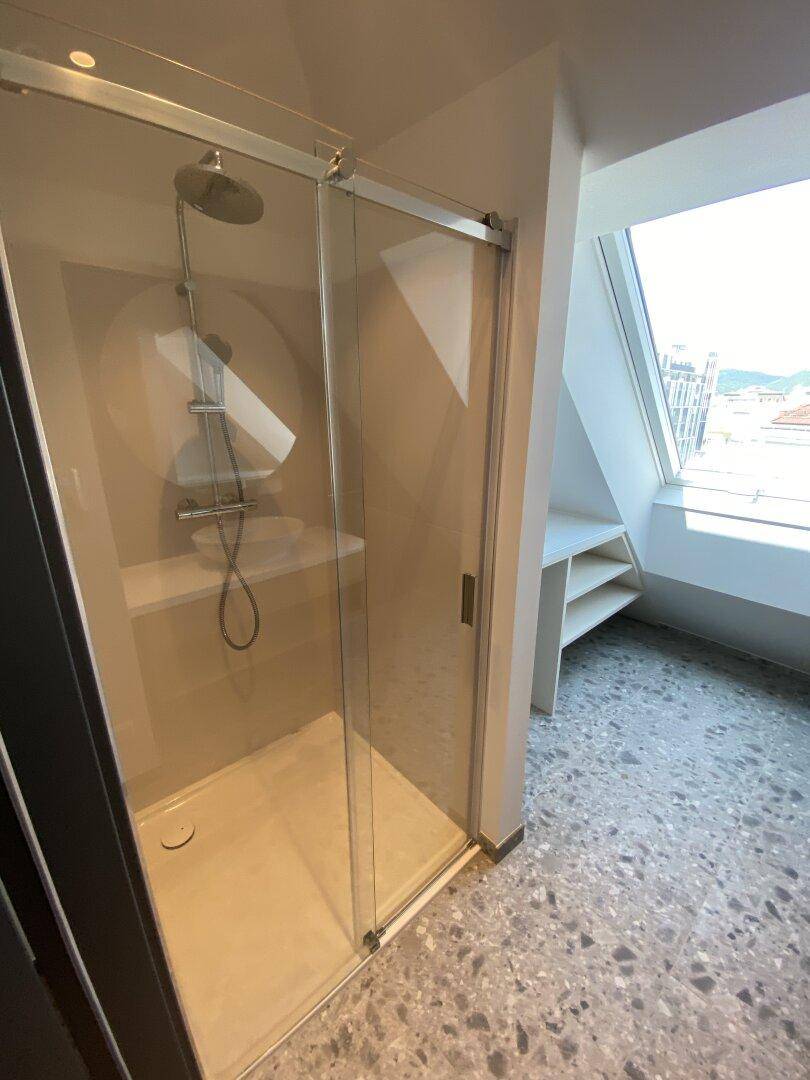 Geräumige begehbare Dusche mit Glasabtrennung und modernem Duschkopf im Badezimmer.