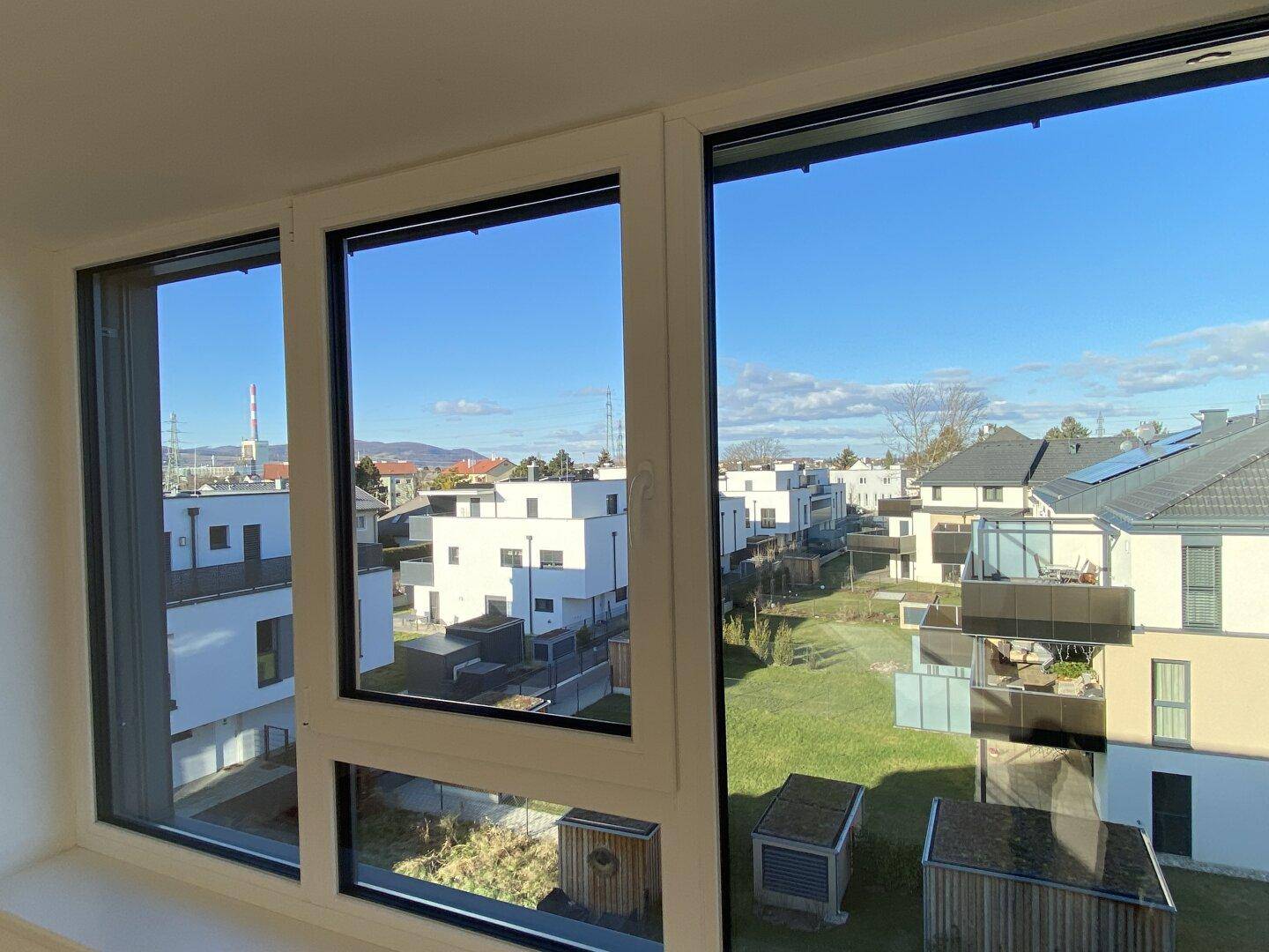 Weitblick aus dem Fenster auf die umliegende Wohnsiedlung und grüne Flächen.