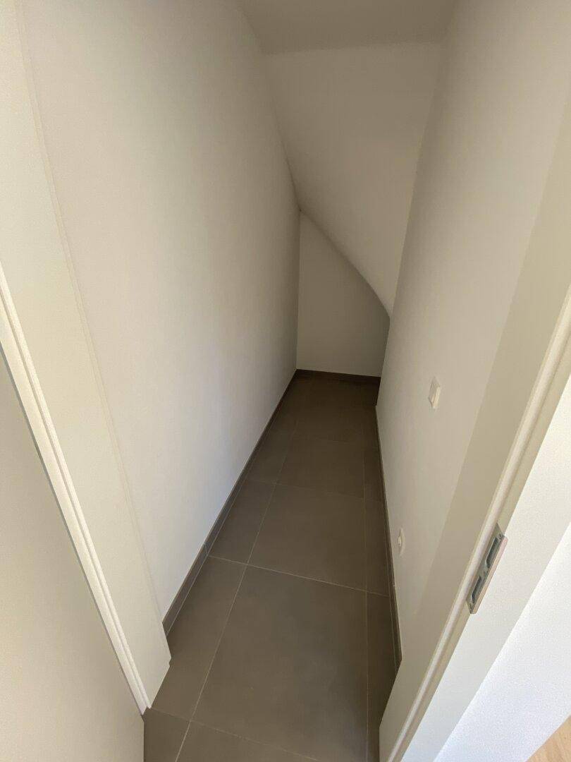 Praktischer Abstellraum unter der Treppe mit Fliesenboden, ideal für zusätzlichen Stauraum.
