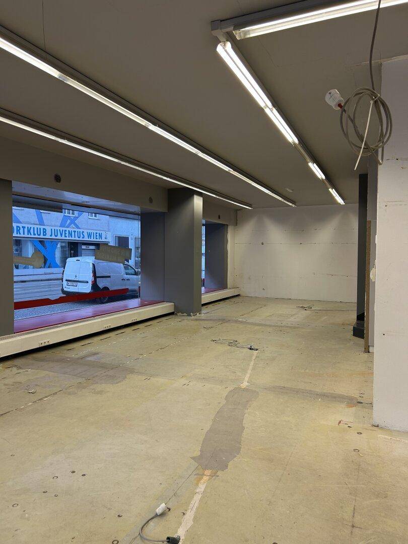Heller Geschäftsraum mit großen Fenstern und Blick auf die Straße, bereit für die individuelle Gestaltung und Nutzung.
