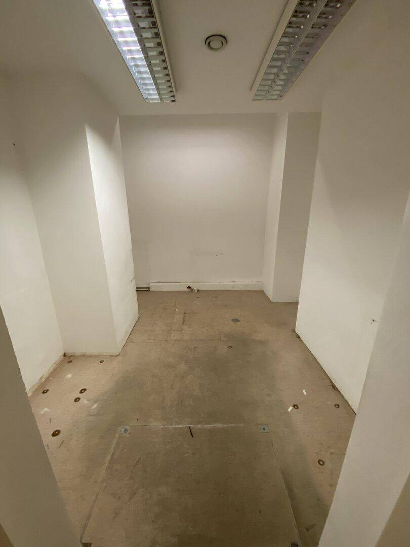 Leerer Raum mit weißen Wänden und Deckenleuchten, bereit für die individuelle Gestaltung und Einrichtung.