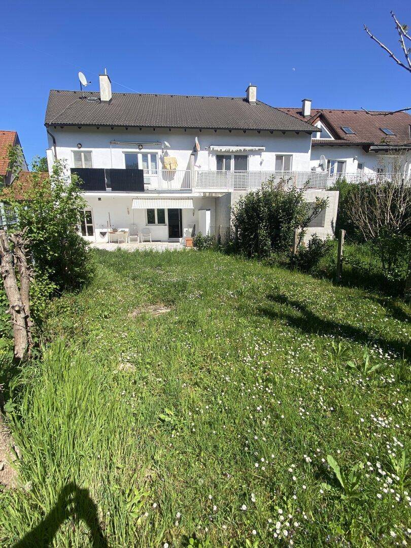 Großer, sonniger Gartenbereich hinter dem Haus mit viel Grün und Blumen.