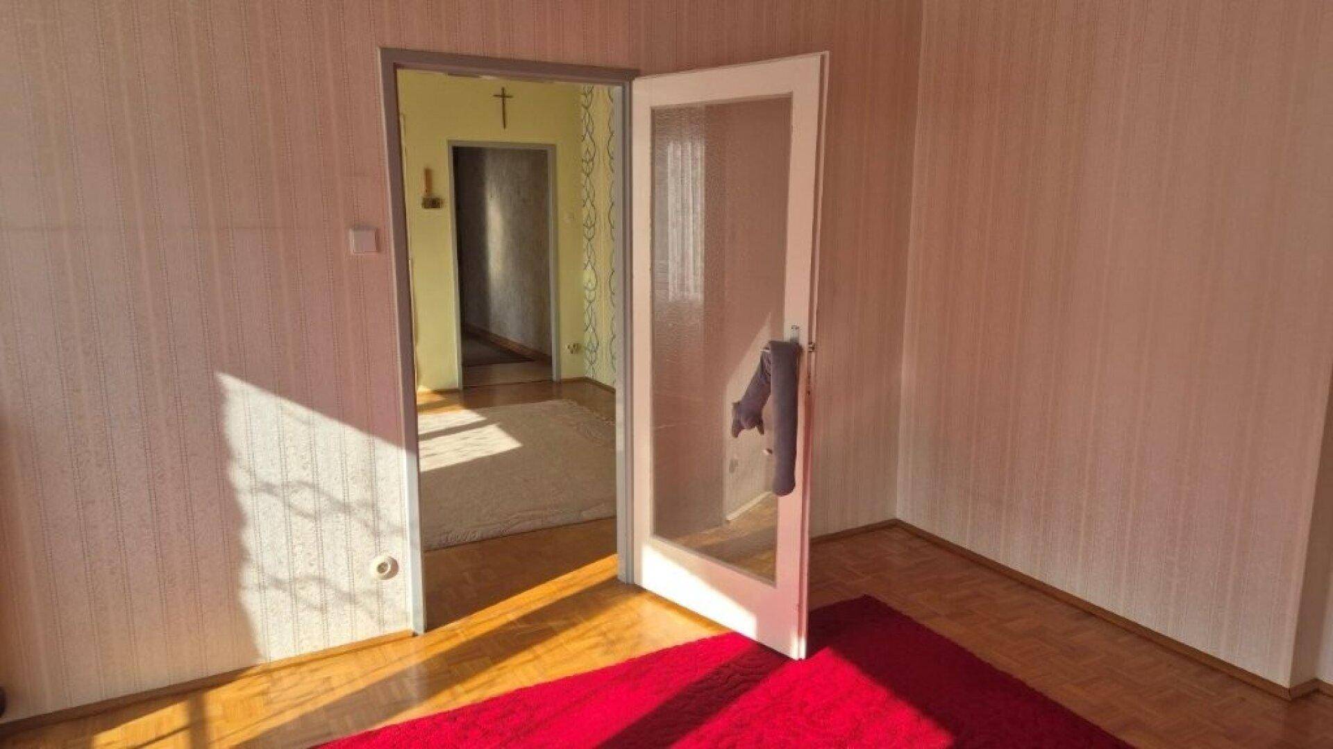 Durchgang zwischen zwei Räumen mit Parkettboden und viel Tageslicht.