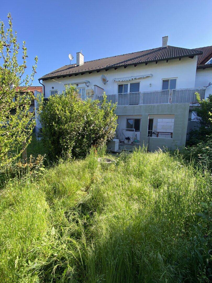 Großer, ungenutzter Gartenbereich hinter dem Haus mit viel Grün.