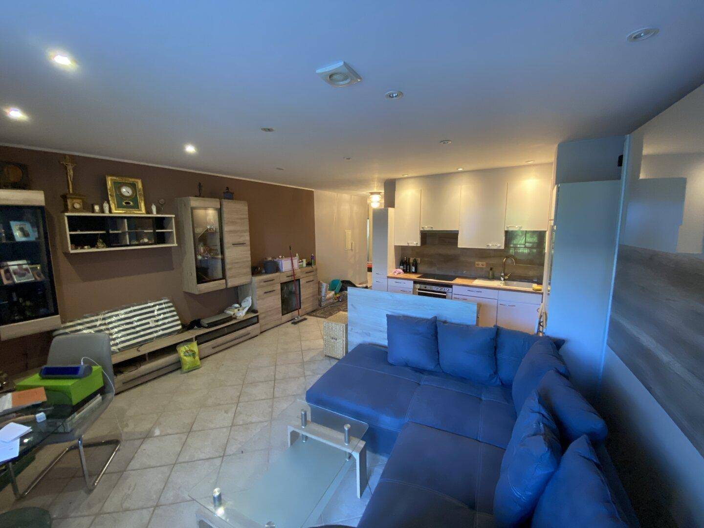 Offener Wohnbereich mit moderner Küche, Sofa und Essbereich.