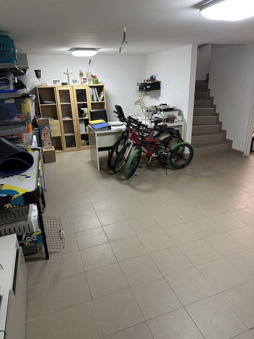 Geräumiger Kellerraum mit Fliesenboden, der als Hobbyraum und Abstellfläche genutzt wird, mit Treppenzugang.