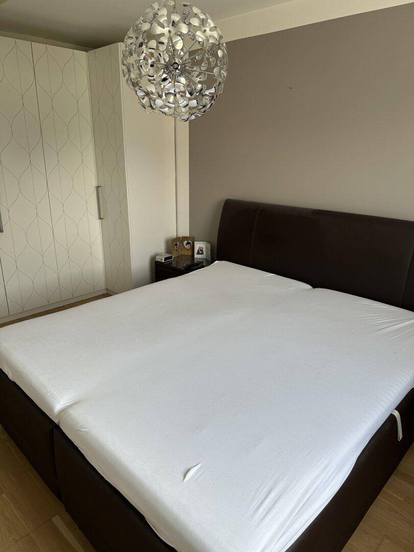 Helles Schlafzimmer mit Doppelbett und geräumigem Kleiderschrank, ideal für erholsame Nächte.