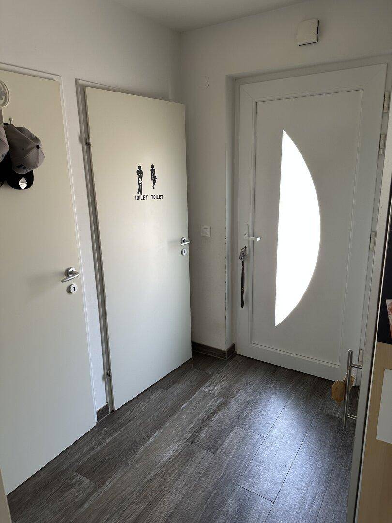 Heller Flur mit mehreren Türen, darunter der Zugang zum Gäste-WC, einladend und praktisch.