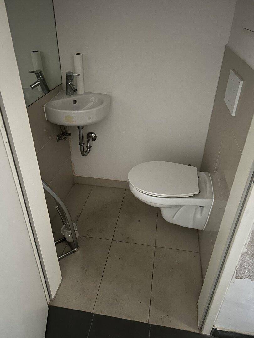 Gästetoilette mit wandhängendem WC und kleinem Waschbecken, praktisch und platzsparend.