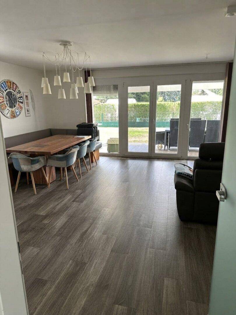 Geräumiger Essbereich mit großem Holztisch, Sitzbank und Zugang zur Terrasse.