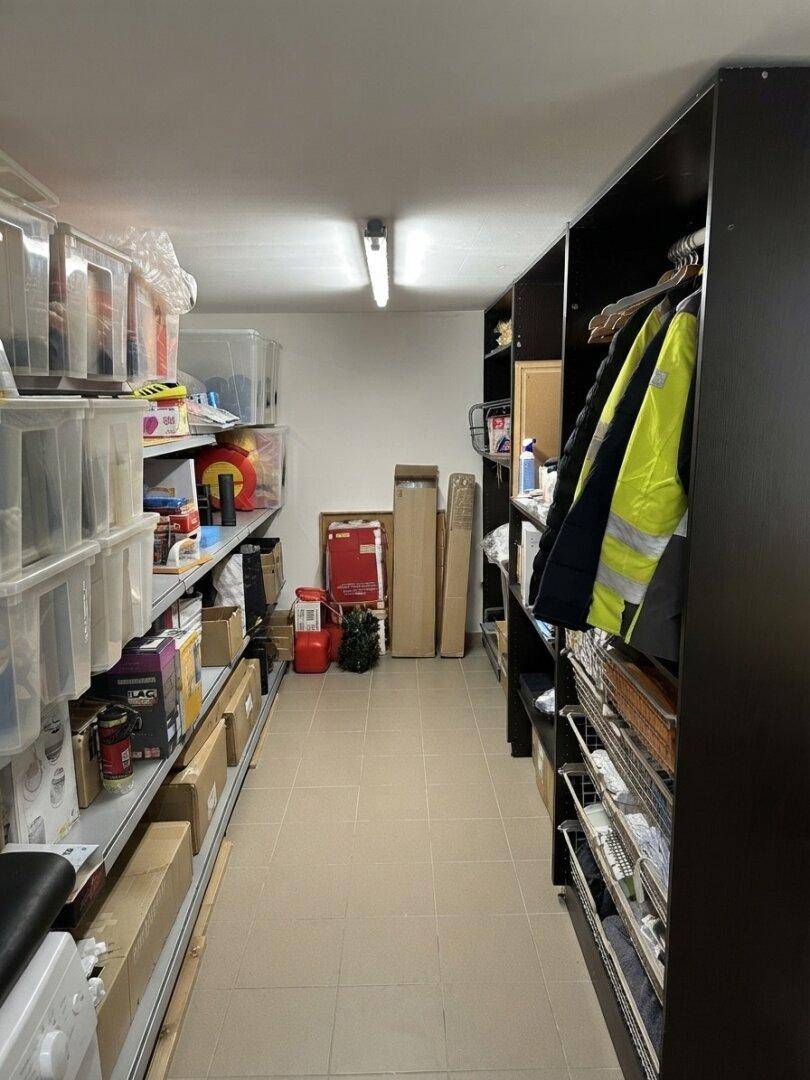 Geräumiger Abstellraum mit Regalen, Lagerboxen und Fliesenboden für diverse Gegenstände.