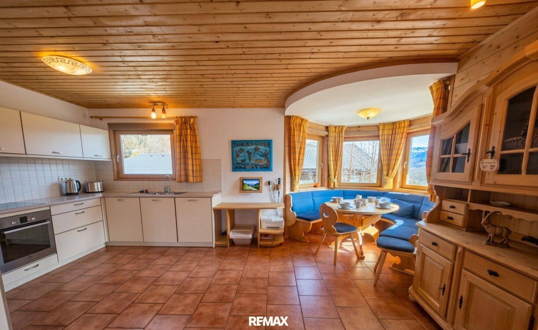 Gemütliche Küche im Landhausstil mit Essbereich und Holzdecke.