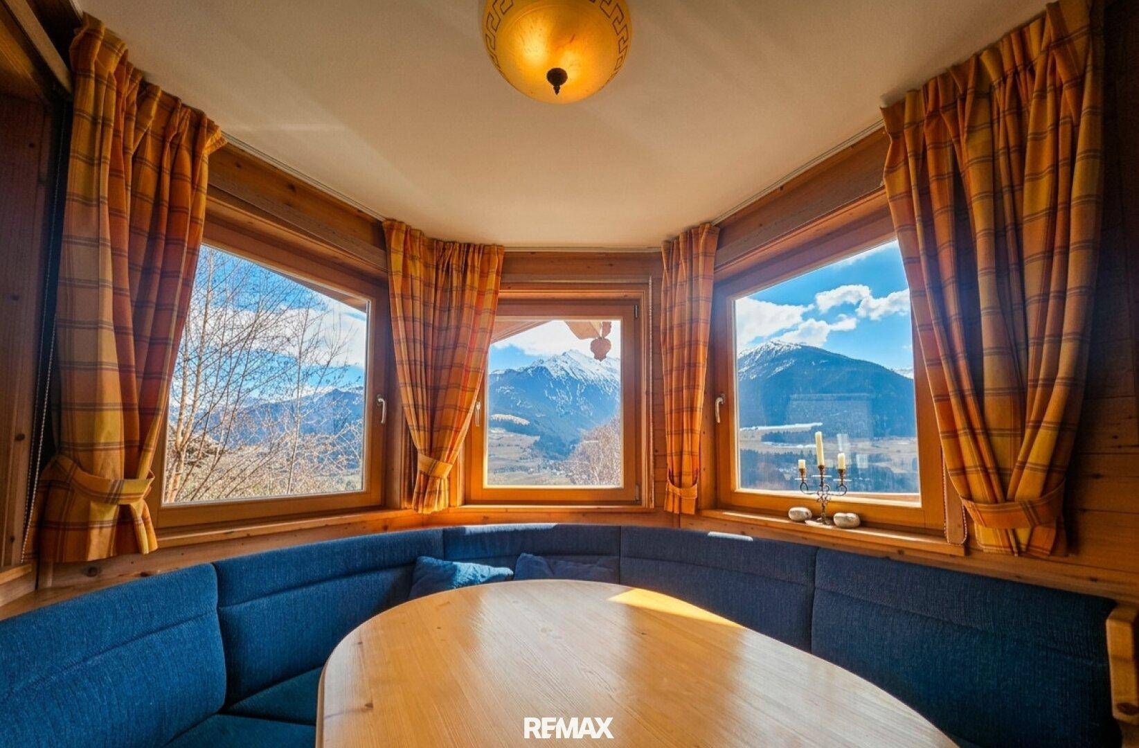 Heller Essbereich mit Eckbank und Panoramablick auf die umliegenden Berge.