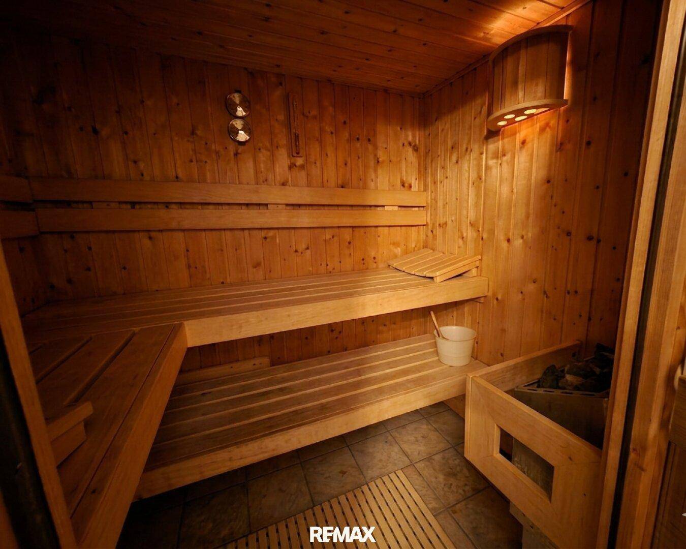 Traditionelle Holzsauna mit Bänken und Saunaofen für Entspannung.