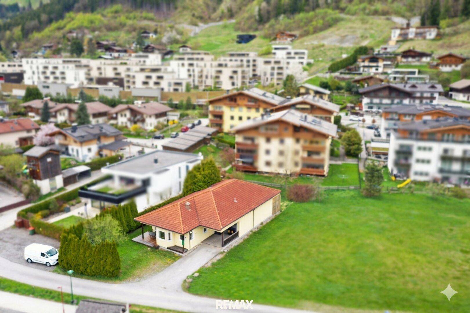 Luftaufnahme des Hauses in einer Wohnsiedlung mit Blick auf die umliegende Berglandschaft.