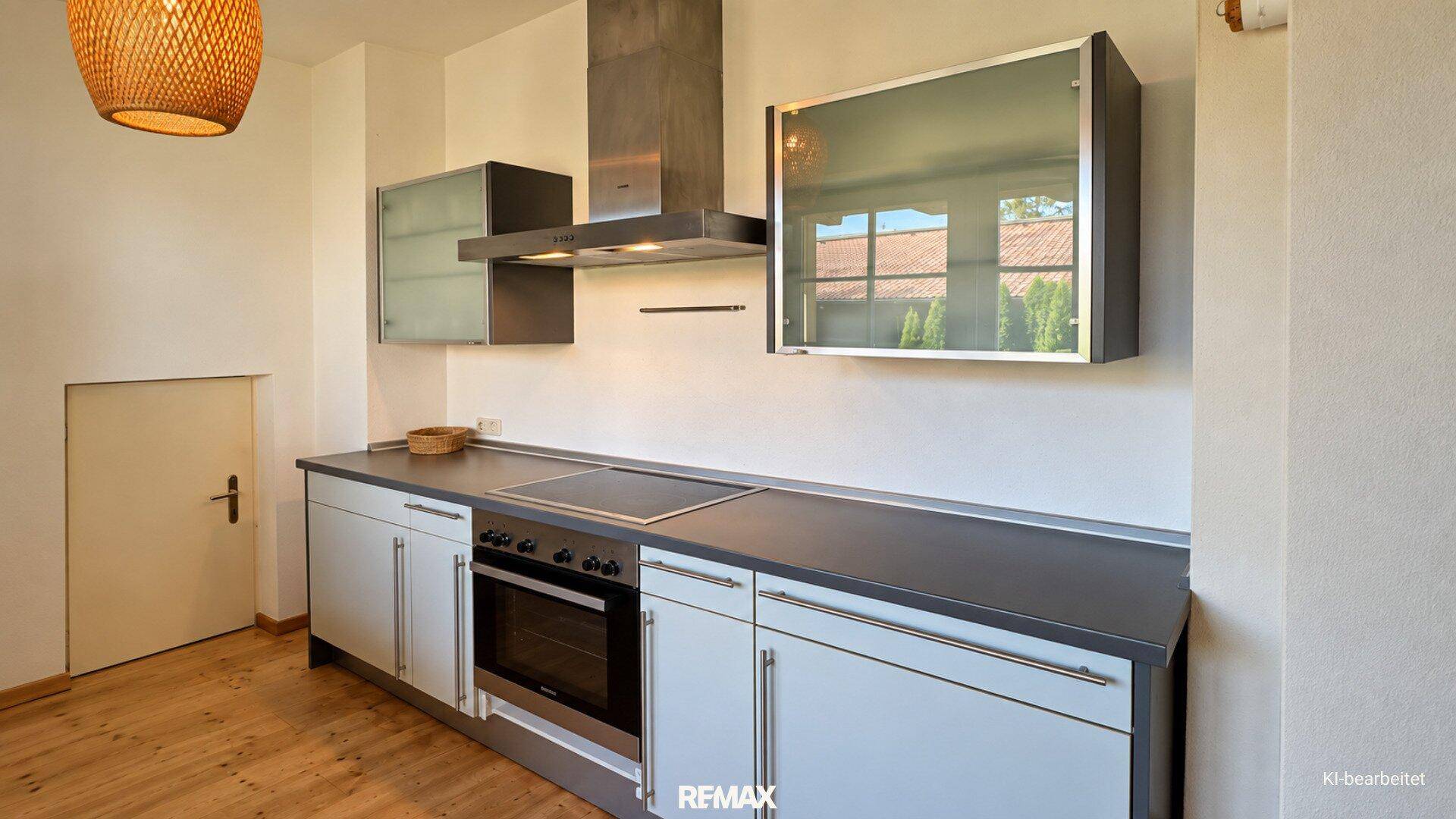 Funktionale Küchenzeile mit Herd, Backofen und Dunstabzugshaube in hellem Design.