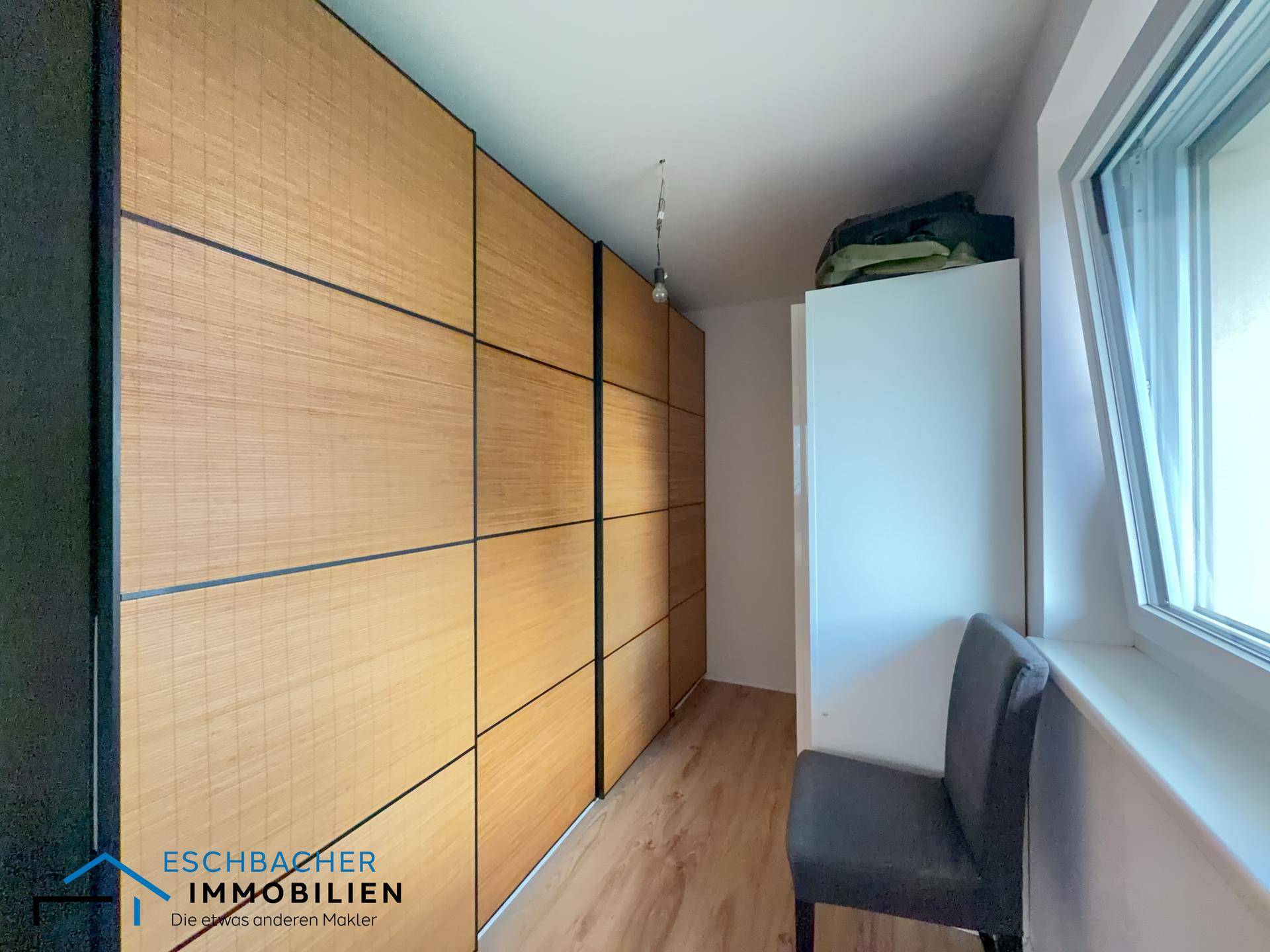Ankleidezimmer mit großen Einbauschränken und Fenster für natürliches Licht.