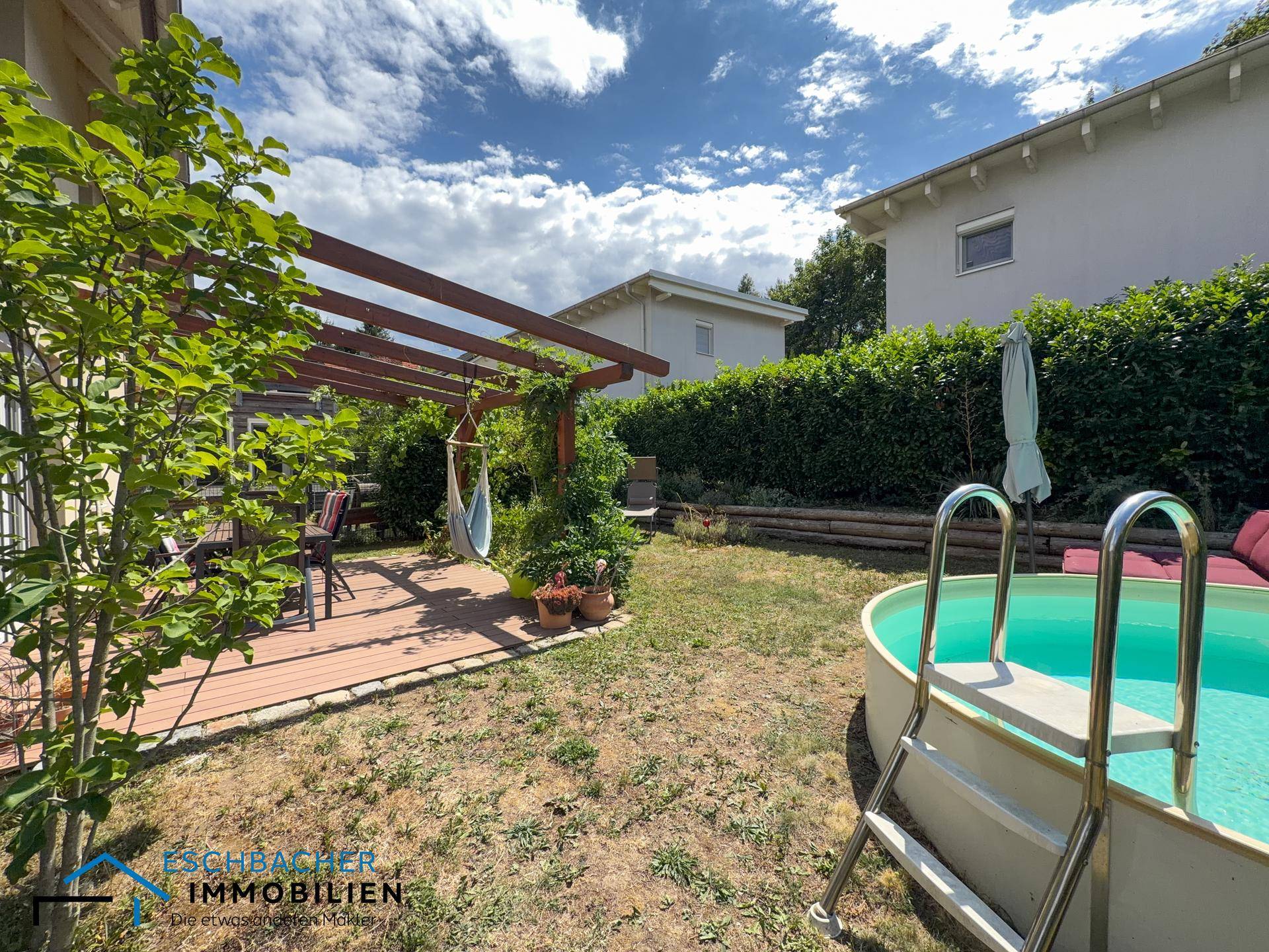 Gartenbereich mit Terrasse, Pool und viel Grün, ideal für Entspannung im Freien.