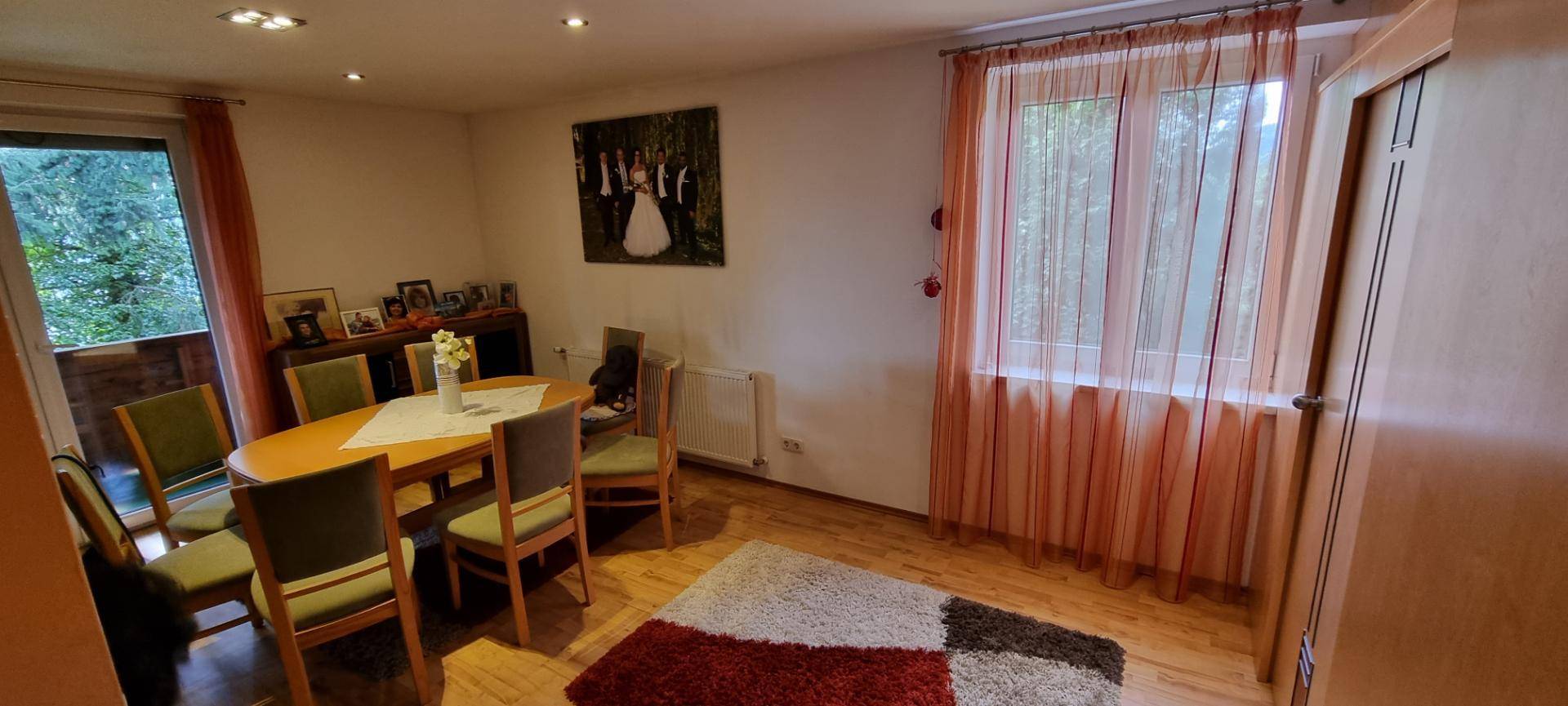 Heller Essbereich mit Holztisch und Stühlen, großen Fenstern und Zugang zum Außenbereich.