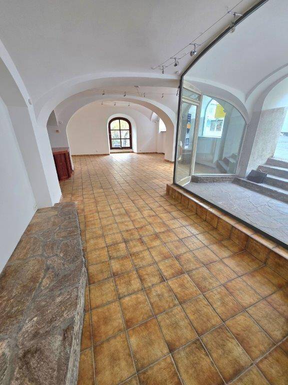 Großer Raum mit Terrakotta-Fliesenboden, hohen Gewölbedecken und einem charakteristischen Rundbogenfenster.