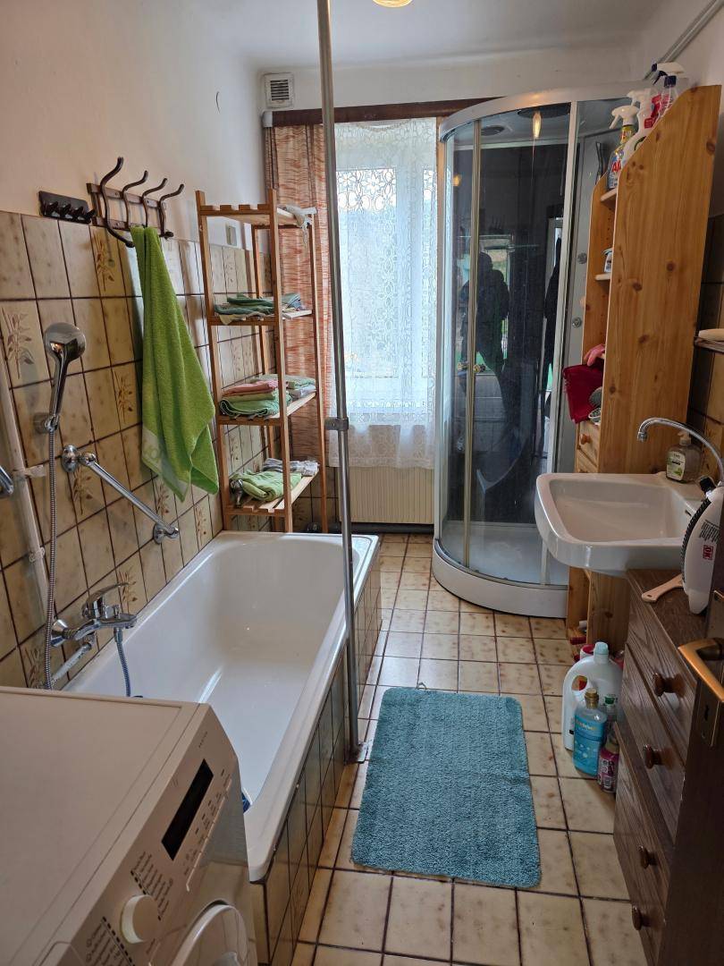 Badezimmer mit Badewanne, Duschkabine, Waschbecken und gefliestem Boden in traditionellem Stil.