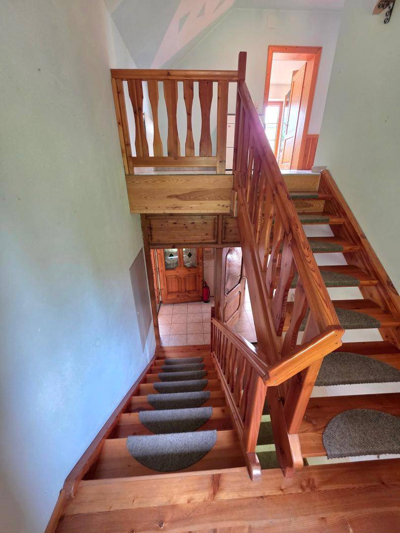 Holztreppe mit Teppichläufern, die die verschiedenen Ebenen des Hauses verbindet.