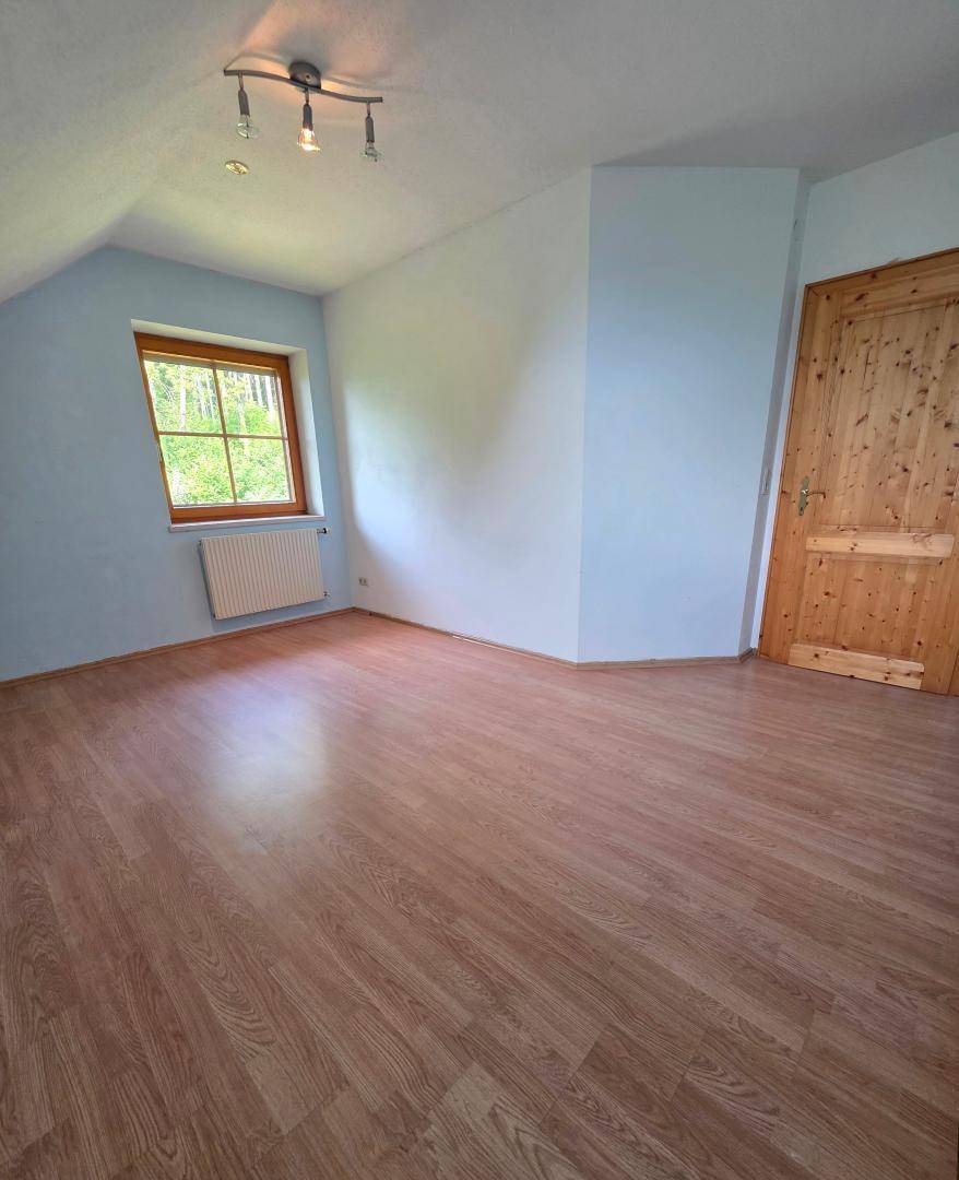 Gemütliches Schlafzimmer mit Laminatboden und Fenster, ideal als Kinder- oder Gästezimmer.