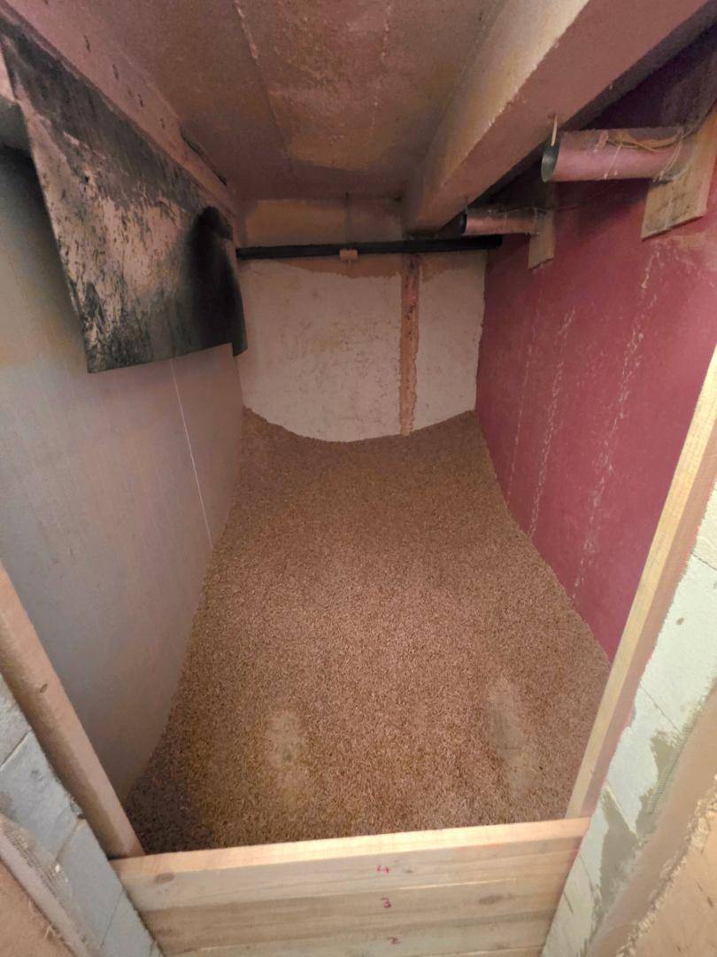 Pelletlagerraum im Keller, gefüllt mit Holzpellets für die Heizungsanlage.