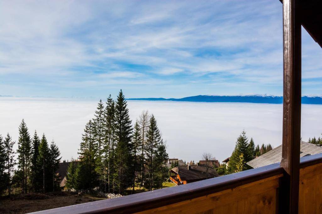 Atemberaubender Blick vom Balkon über eine dichte Nebeldecke und ferne Berge.